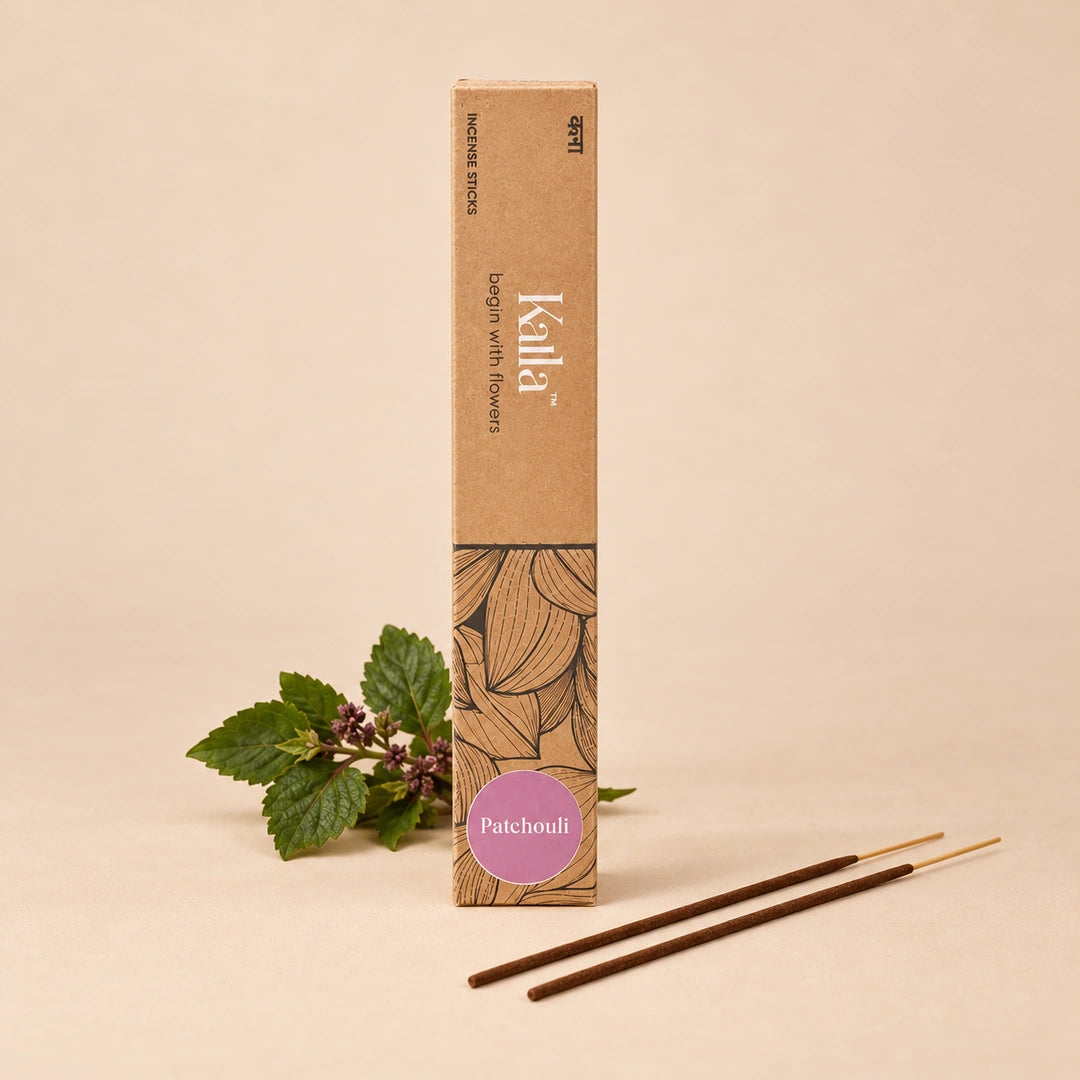 Kalla Patchouli Incense Sticks – eco-conscious brown box with botanical line art and a purple label marked “Patchouli,” placed on a textured stone surface alongside neatly arranged incense sticks and natural decorative elements for a calming, earthy aesthetic.