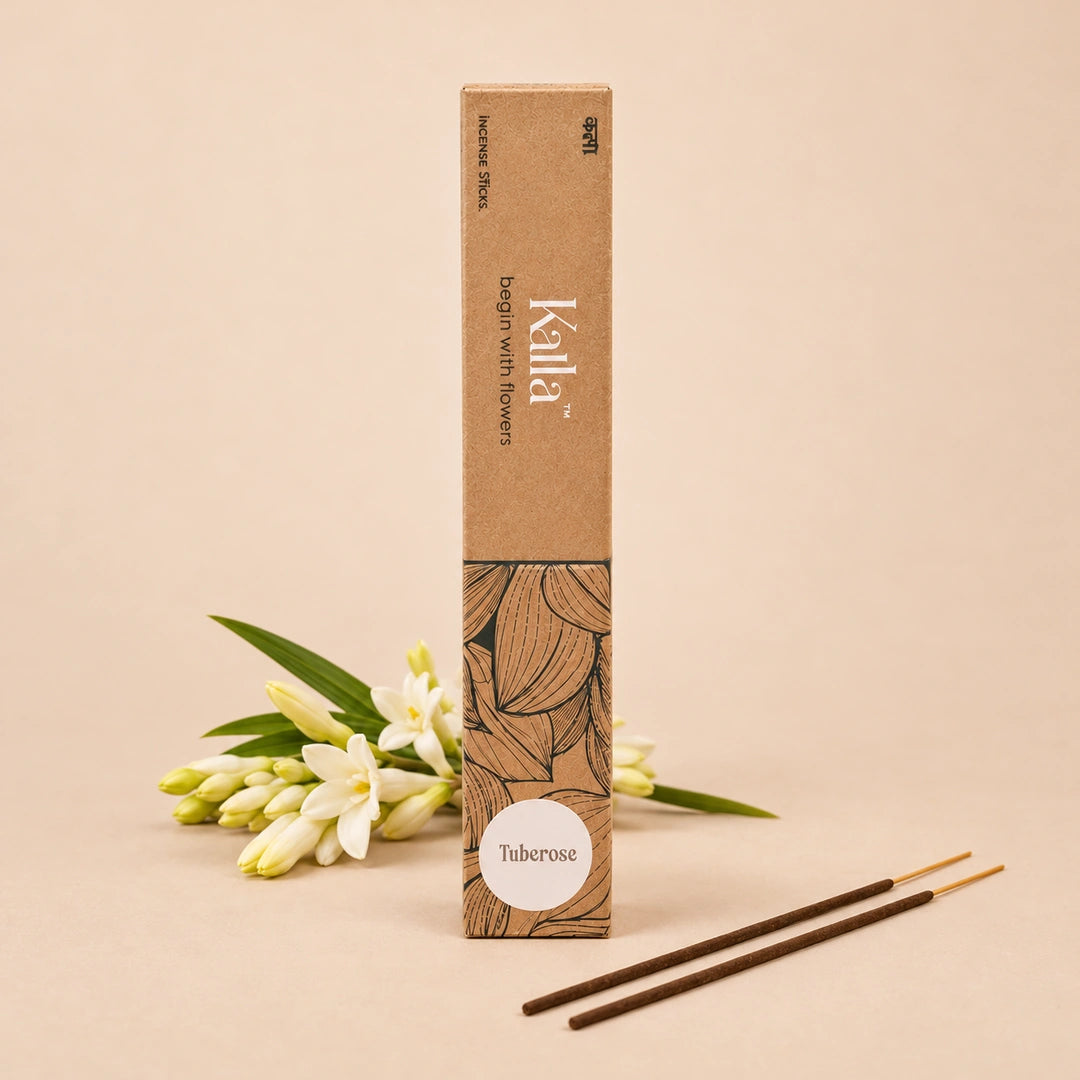 Kalla Tuberose Incense Sticks – eco-friendly brown packaging with artistic floral line designs and a white label marked “Tuberose,” displayed on a textured grey surface with incense sticks arranged neatly, surrounded by natural decorative elements for a serene and floral ambiance.
