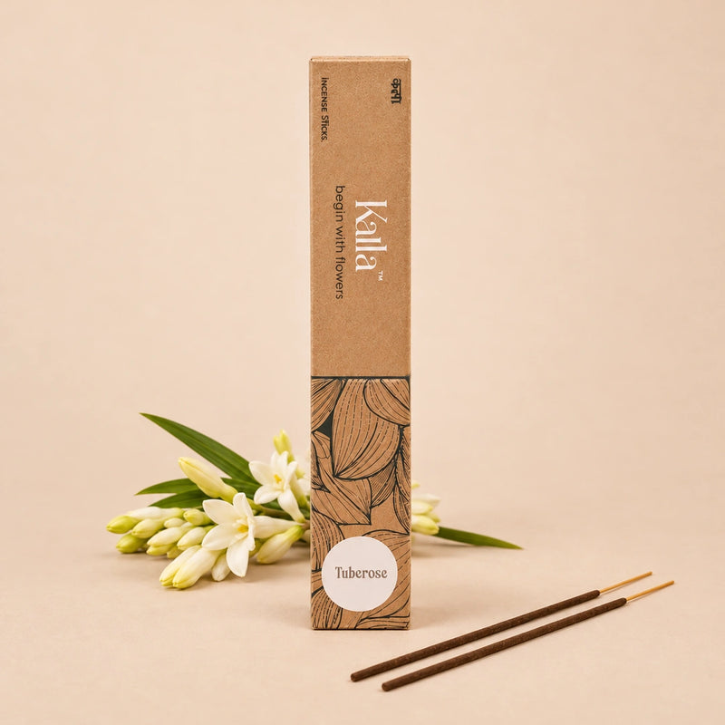 Kalla Tuberose Incense Sticks – eco-friendly brown packaging with artistic floral line designs and a white label marked “Tuberose,” displayed on a textured grey surface with incense sticks arranged neatly, surrounded by natural decorative elements for a serene and floral ambiance.